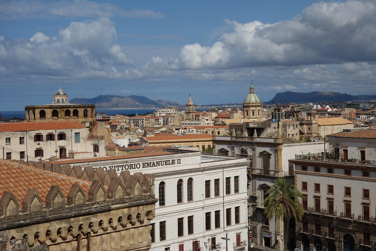 Vista panoramica di Palermo da una terrazza, con skyline e monumenti storici sullo sfondo.