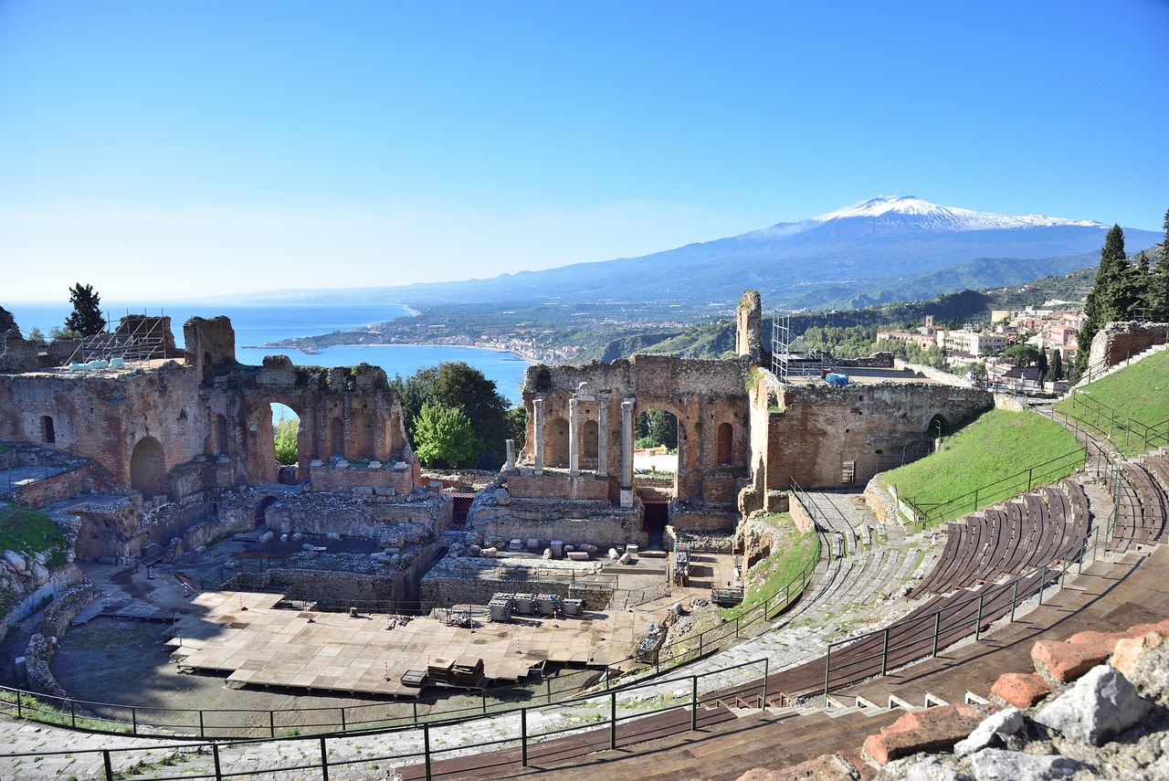 Teatro Greco di Taormina, panorama suggestivo con architettura antica e sfondo montano.