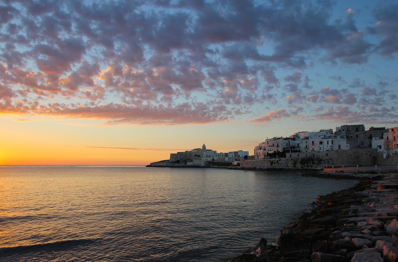 Tramonto mozzafiato sul mare siciliano con colori vibranti e silhouette di palme.