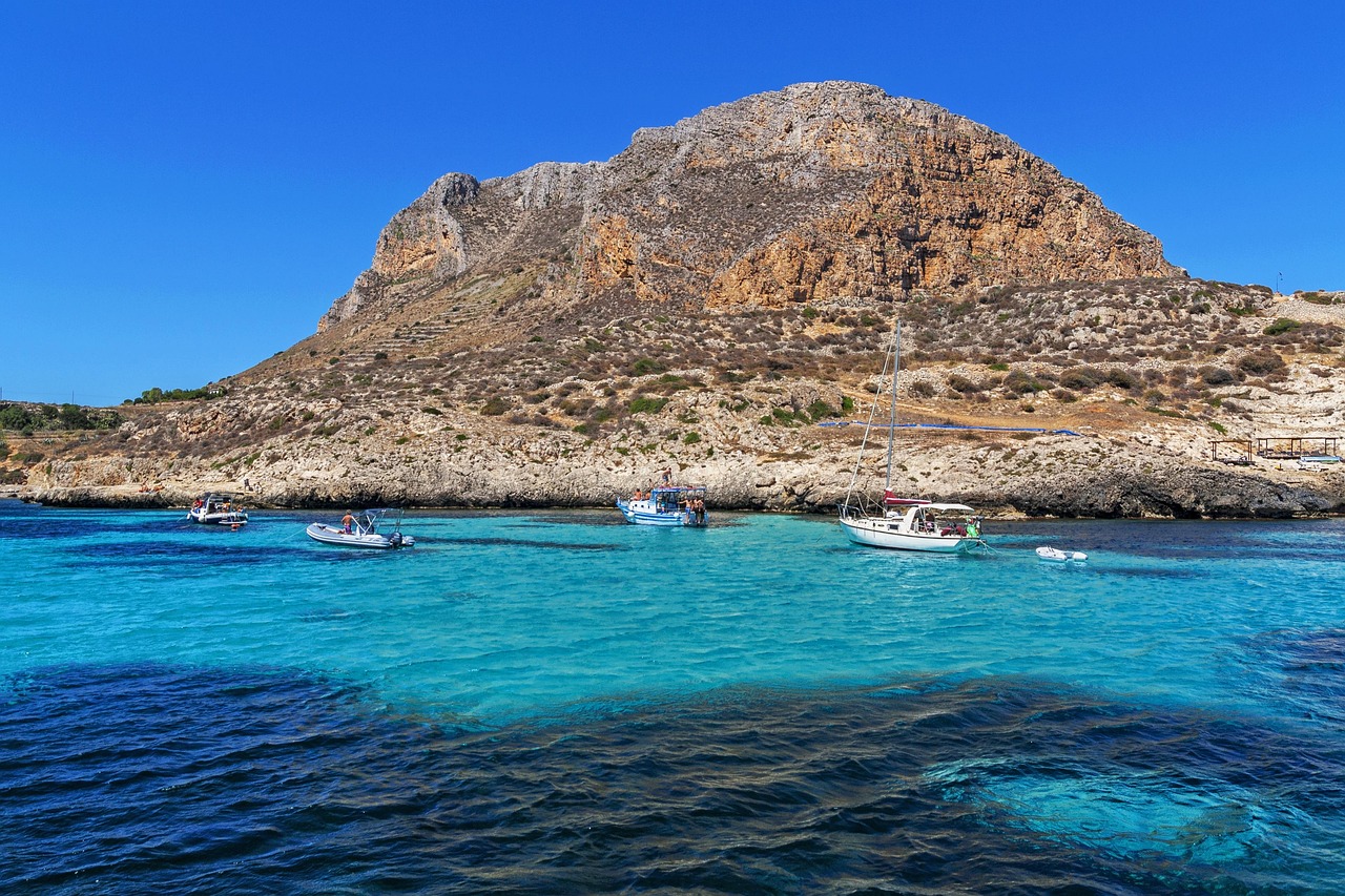 Spiaggia di San Vito Lo Capo con mare cristallino, sentieri per trekking e piatti tipici siciliani.