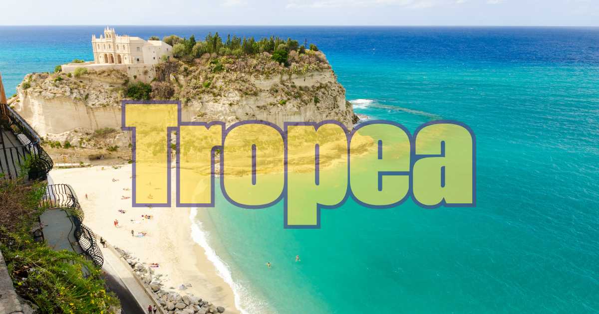 Spiaggia di Tropea con mare cristallino e scogliere imponenti, meta ideale per le vacanze estive.