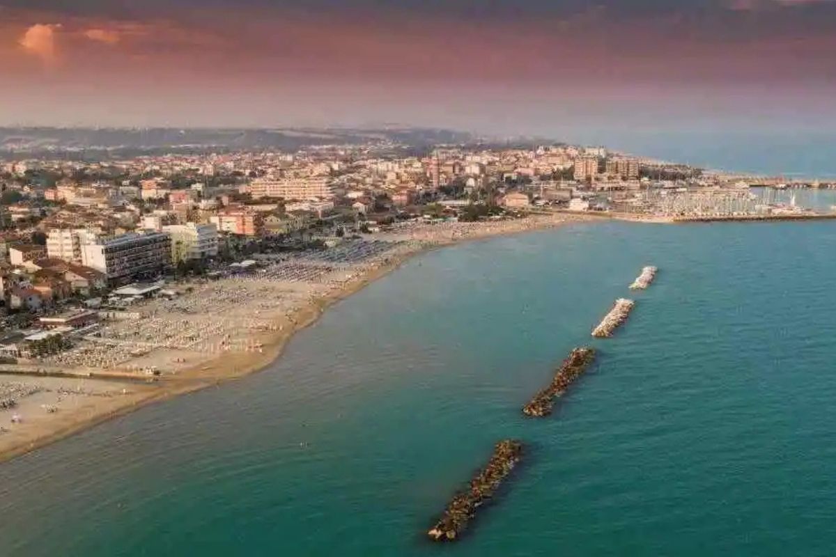 Spiaggia libera in Italia con sabbia dorata e mare cristallino, ideale per una giornata di relax.