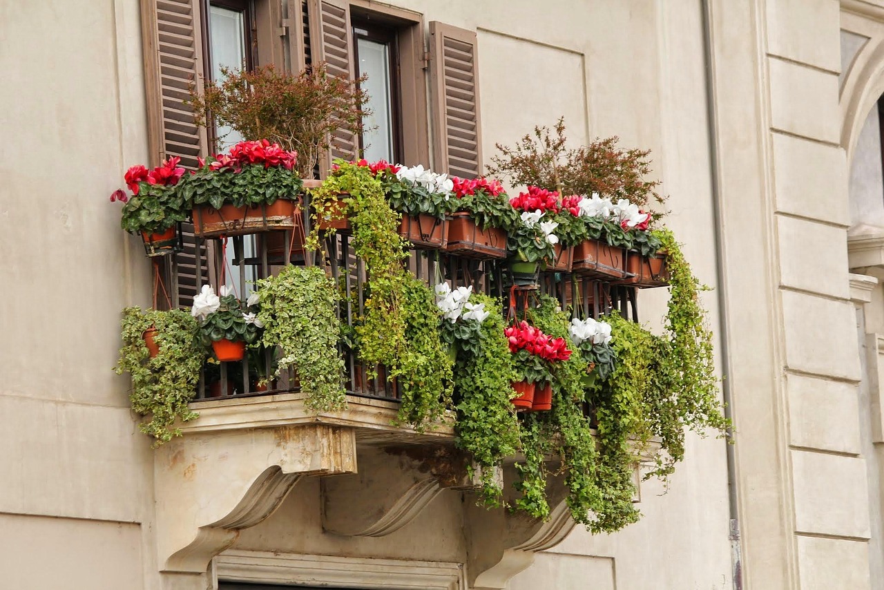 Balcone estivo con piante fiorite e arredo elegante, perfetto per relax e atmosfera estiva.